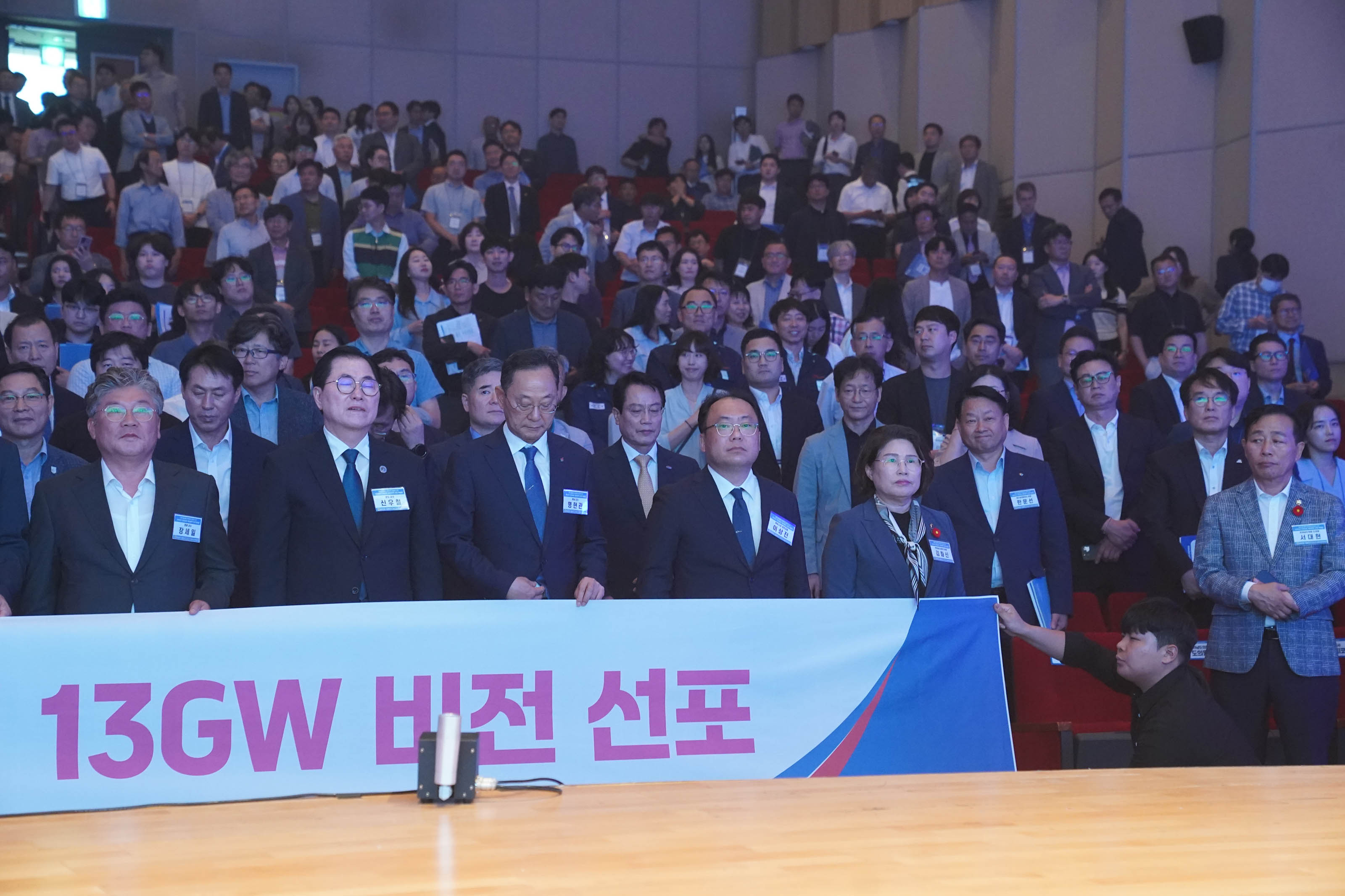 행사장 내빈들이 '13GW 비전 선포'라고 적힌 대형 현수막을 펼쳐 들고 있는 모습.