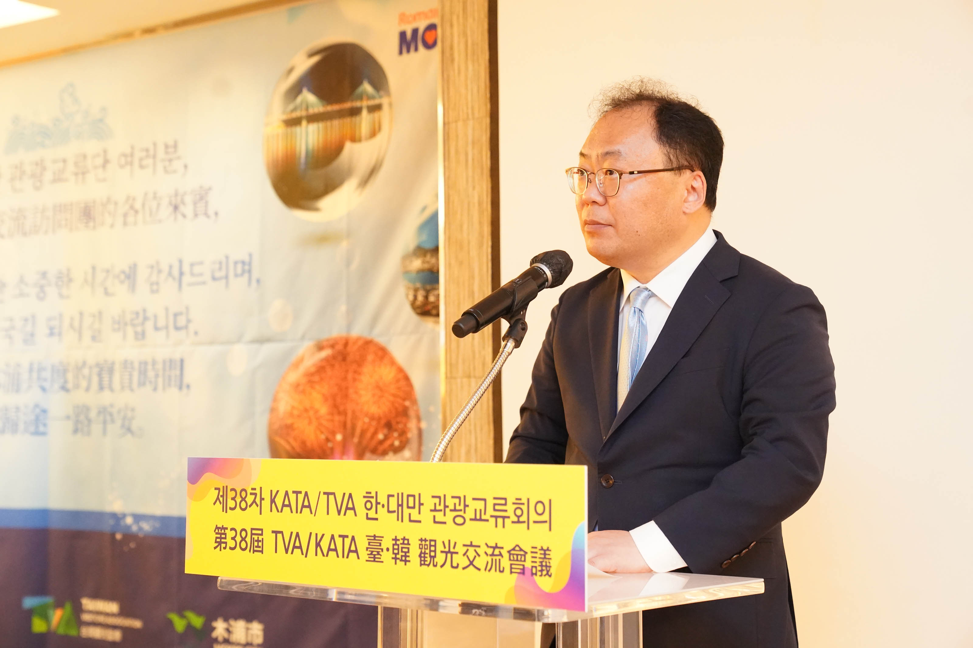 '제38차 KATA/TVA 한·대만 관광교류회의 第38屆 TVA/KATA 臺·韓 觀光交流會議' 문구가 적힌 연단 뒤에서 안경을 쓴 남성이 발언하는 모습.
