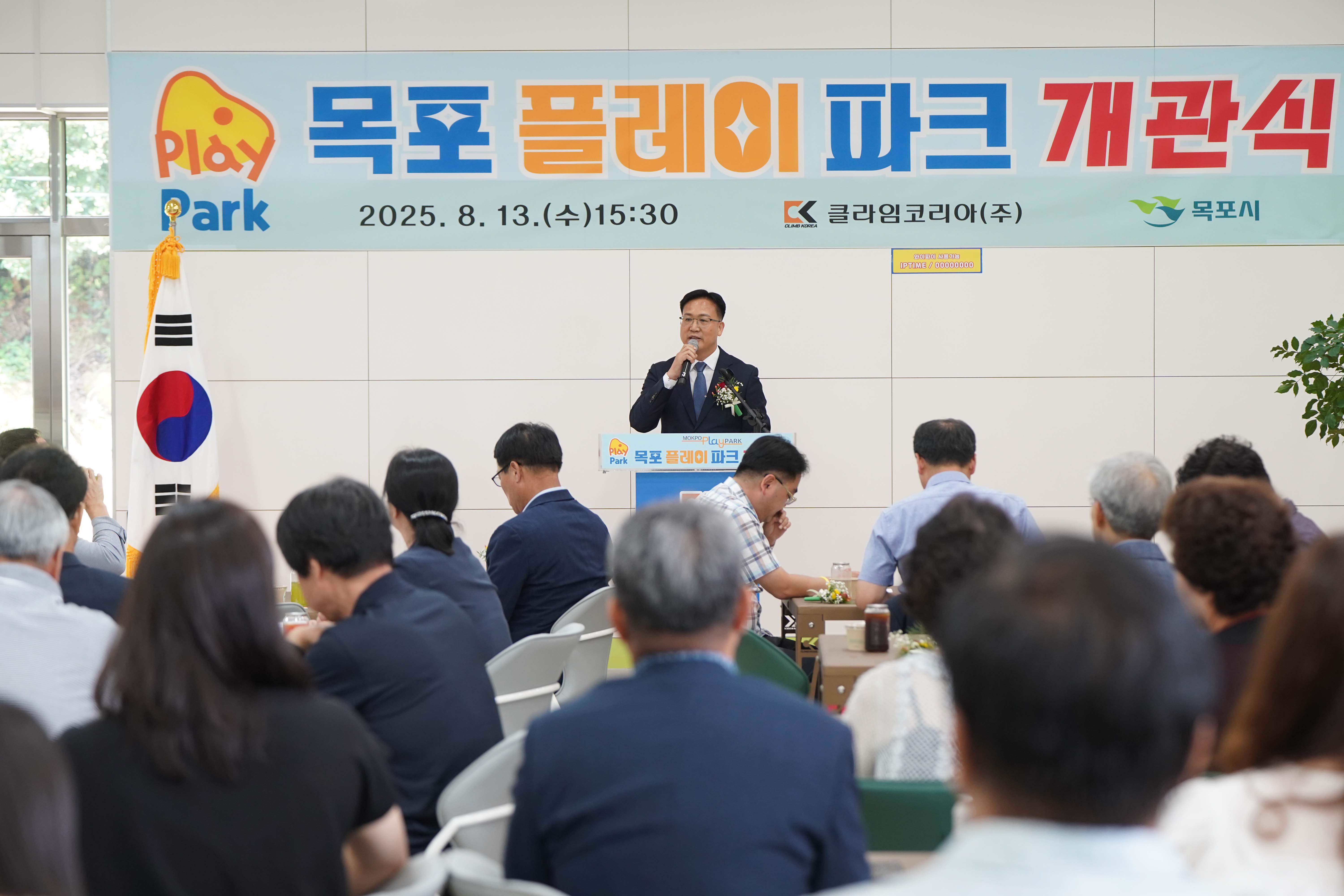 '목포 플레이 파크 개관식'에서 연설 중인 내빈과 이를 경청하는 참석자들의 뒷모습.