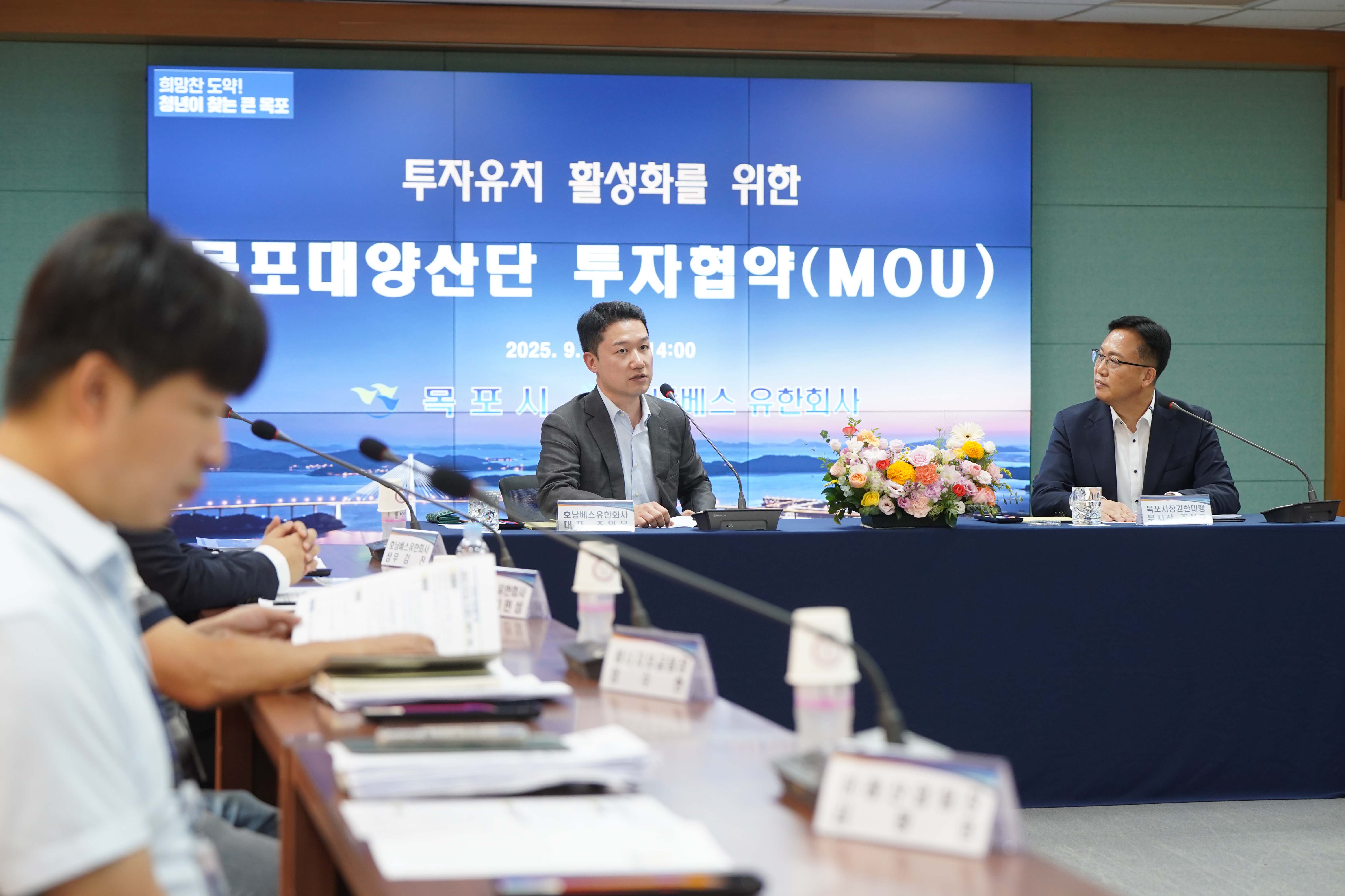 '호남베스유한회사 대표 조언우' 명패 뒤에 앉은 조언우 대표가 마이크를 통해 발언하는 모습. 오른쪽에는 조석훈 부시장이 경청하고 있으며, 스크린에는 '투자유치 활성화를 위한 목포대양산단 투자협약(MOU)' 문구가 보임.