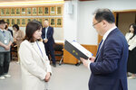 수시인사 임용장 수여식에서 정장을 입은 남성이 아이보리색 재킷을 입은 여성 직원에게 임용장을 전달하는 모습